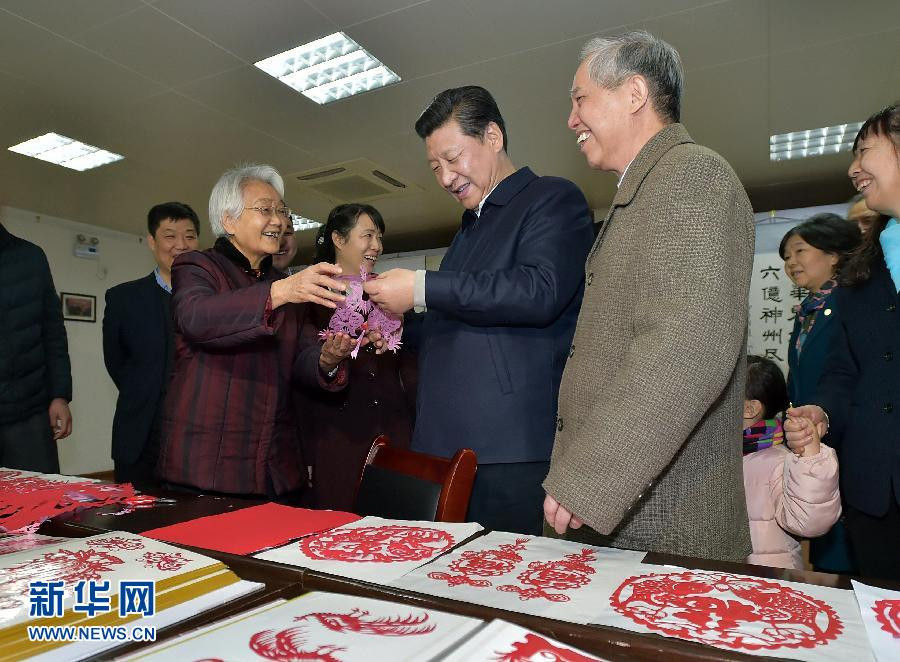 2月15日上午，習(xí)近平在西安市雁塔區(qū)電子城街道二〇五所社區(qū)服務(wù)中心欣賞社區(qū)老人的剪紙作品。新華社記者 李濤 攝