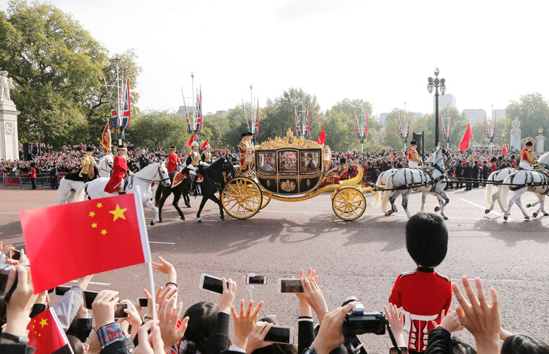 10月20日，對英國進(jìn)行國事訪問的國家主席習(xí)近平出席英國女王伊麗莎白二世在倫敦騎兵檢閱場舉行的隆重歡迎儀式。這是習(xí)近平和夫人彭麗媛在女王夫婦陪同下，乘坐皇家馬車前往白金漢宮下榻。新華社記者 周磊 攝